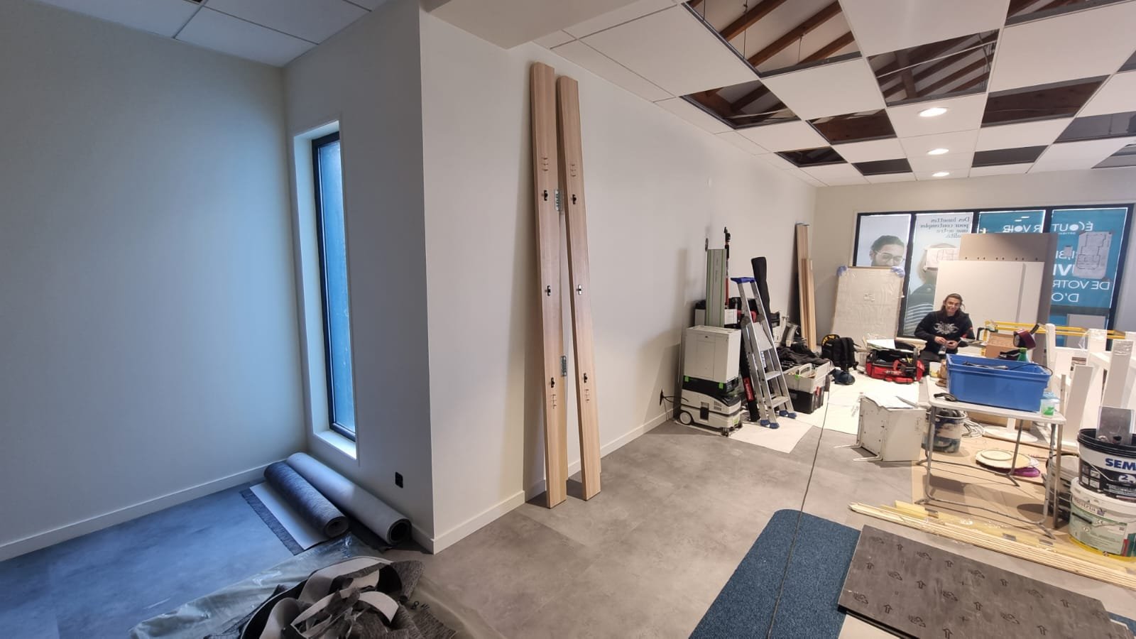 Avant : local en travaux, plafond ouvert, matériaux et outillage au sol