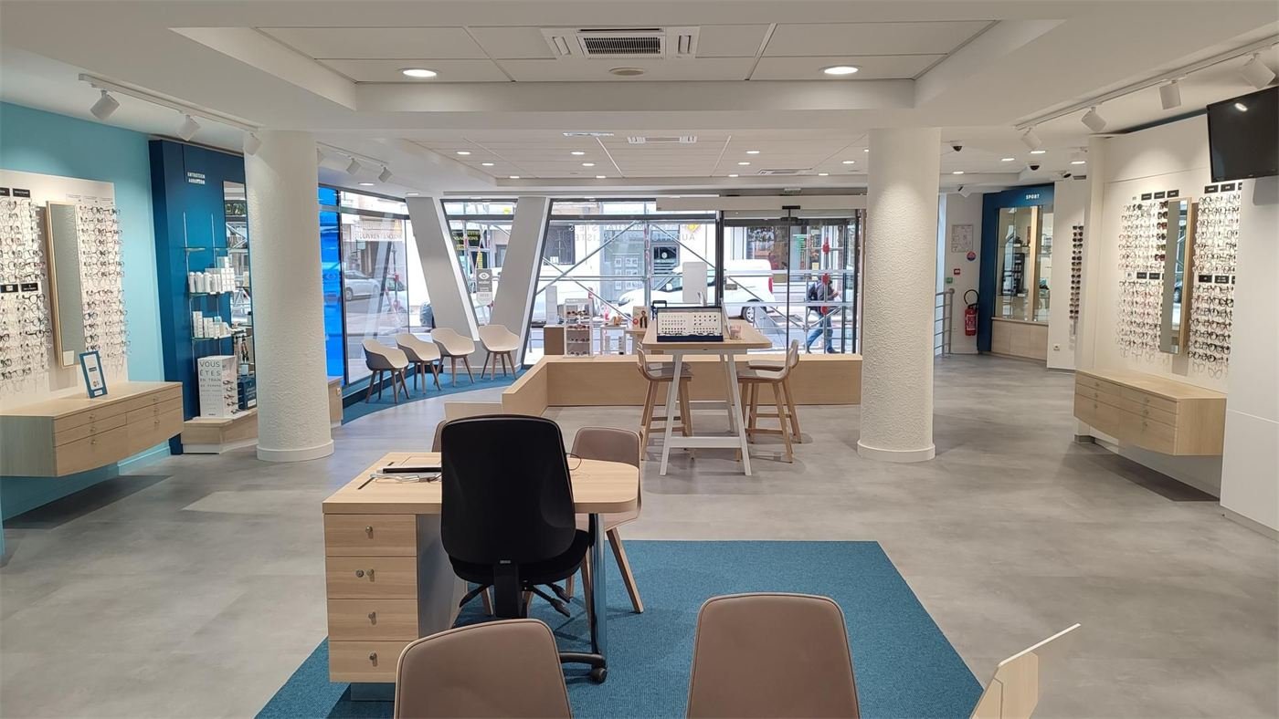 Magasin d'optique à Annecy : murs de montures, bureaux de conseil et espace d'attente