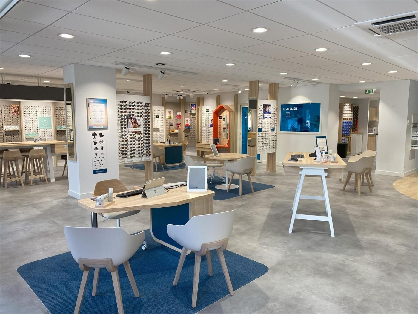 Magasin d'optique à Vichy : bureaux de conseil en bois, murs de montures et atelier